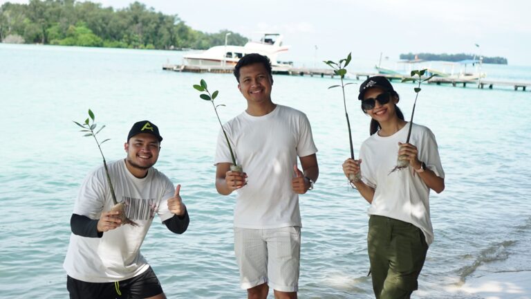 Buat Outing Kantor Anda Jadi Momen Untuk Recharge, Bukan Sekadar Senang-senangmemakai seragam putih Bumi Journey dan memegang bibit mangrove di tepi pantai