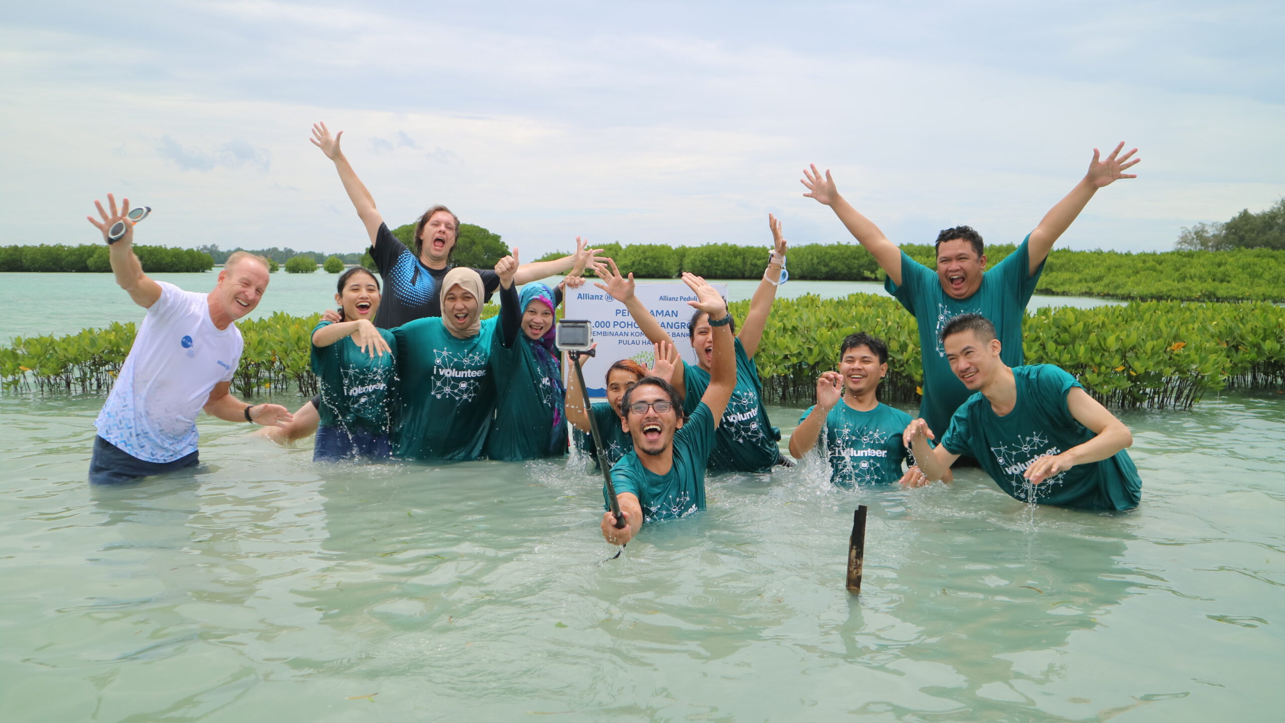 Peserta acara CSR penanaman mangrove di situs penanaman mangrove CarbonEthics di Pulau Harapan berpose di depan tongkat selfie dengan raut wajah bahagia