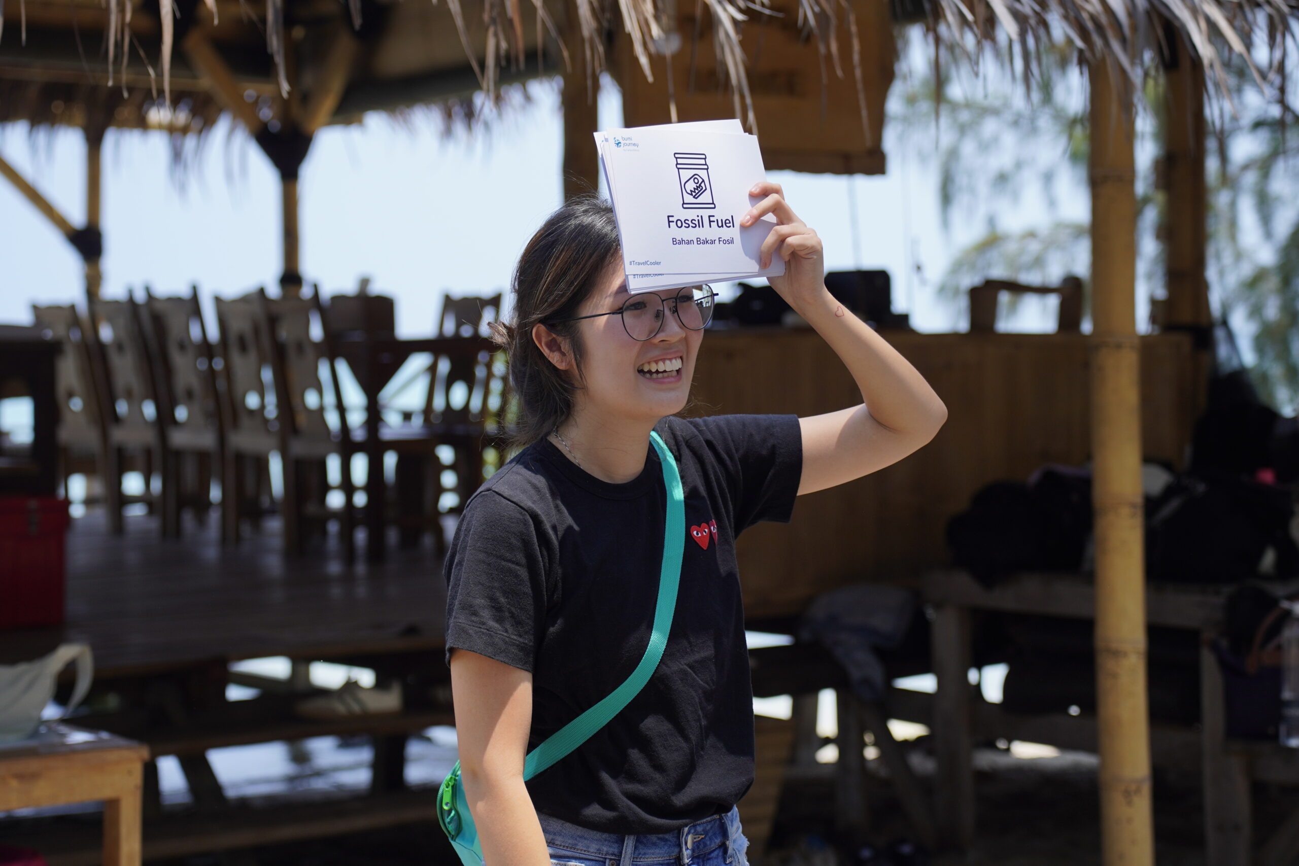 peserta outing kantor Bumi Journey berbaju hitam memegang kartu indeks dalam permainan tebak gaya di depan lounge Desa Laguna